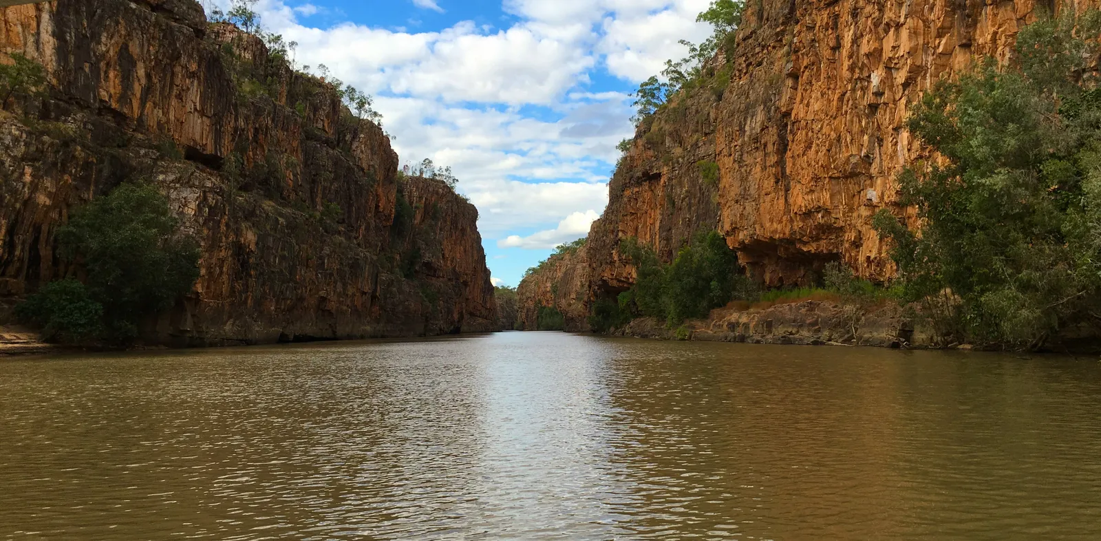 Sandstone walls rising on both sides of still water at Nitmiluk Gorge near Katherine