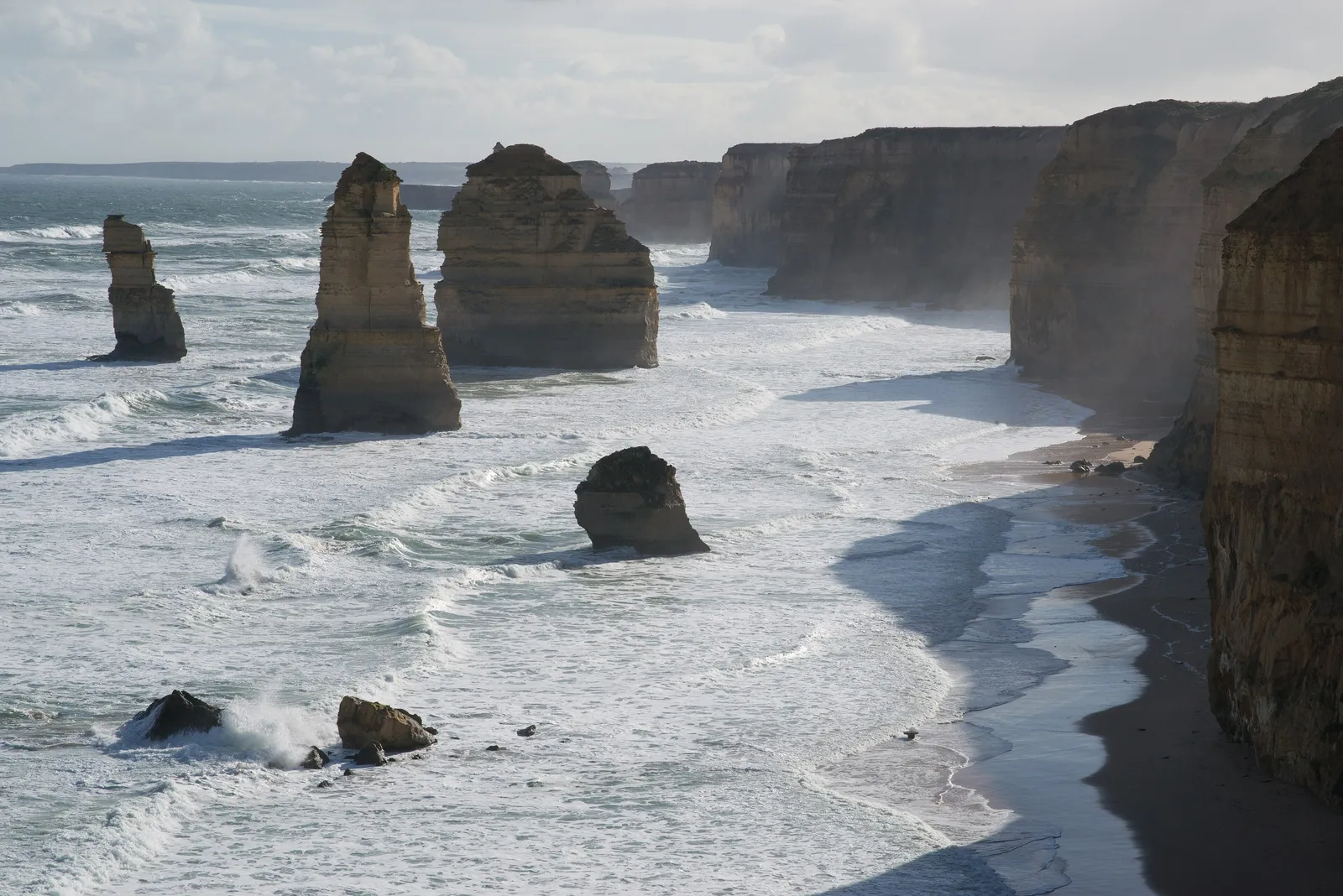 Limestone stacks standing in the surf below cliffs at the Twelve Apostles, Port Campbell National Park